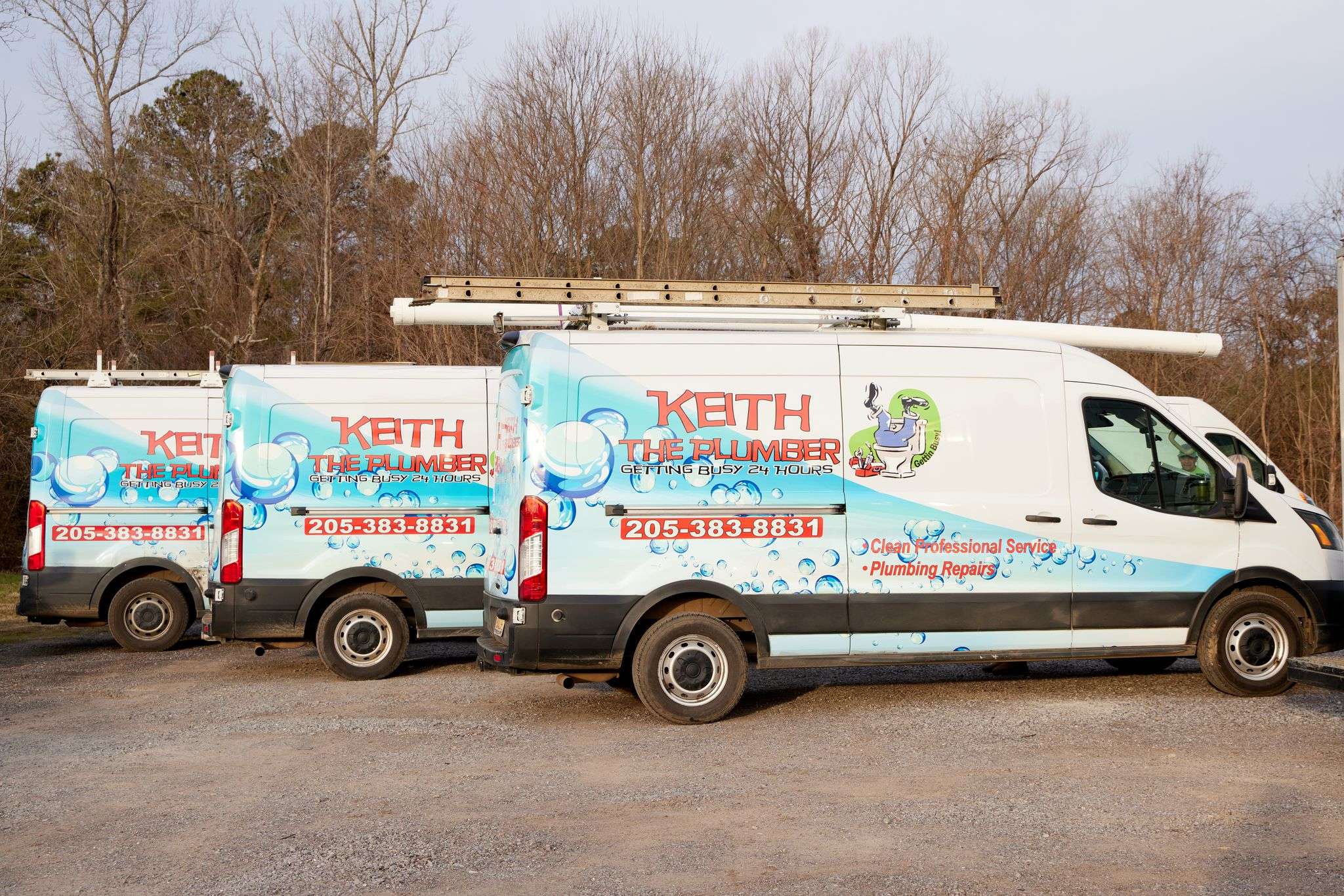 Three white Keith The Plumber service vans parked in a row